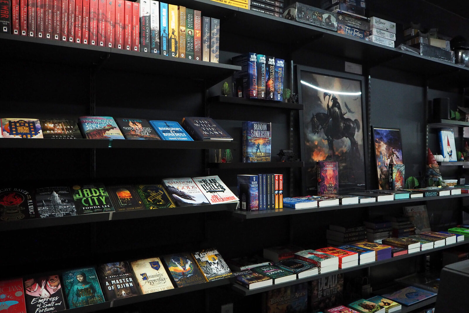 The same fantasy wall from a little further back, with series hardcovers on the top shelf